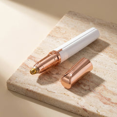 The Milara Brow Pen and its rose-gold cap resting on travertine stone
